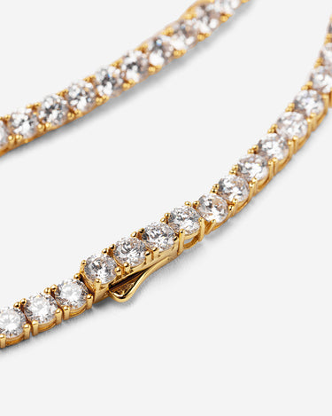 Crystal Embrace goudkleurig tennis ketting, symbool van zuiverheid en sprankelende energie.